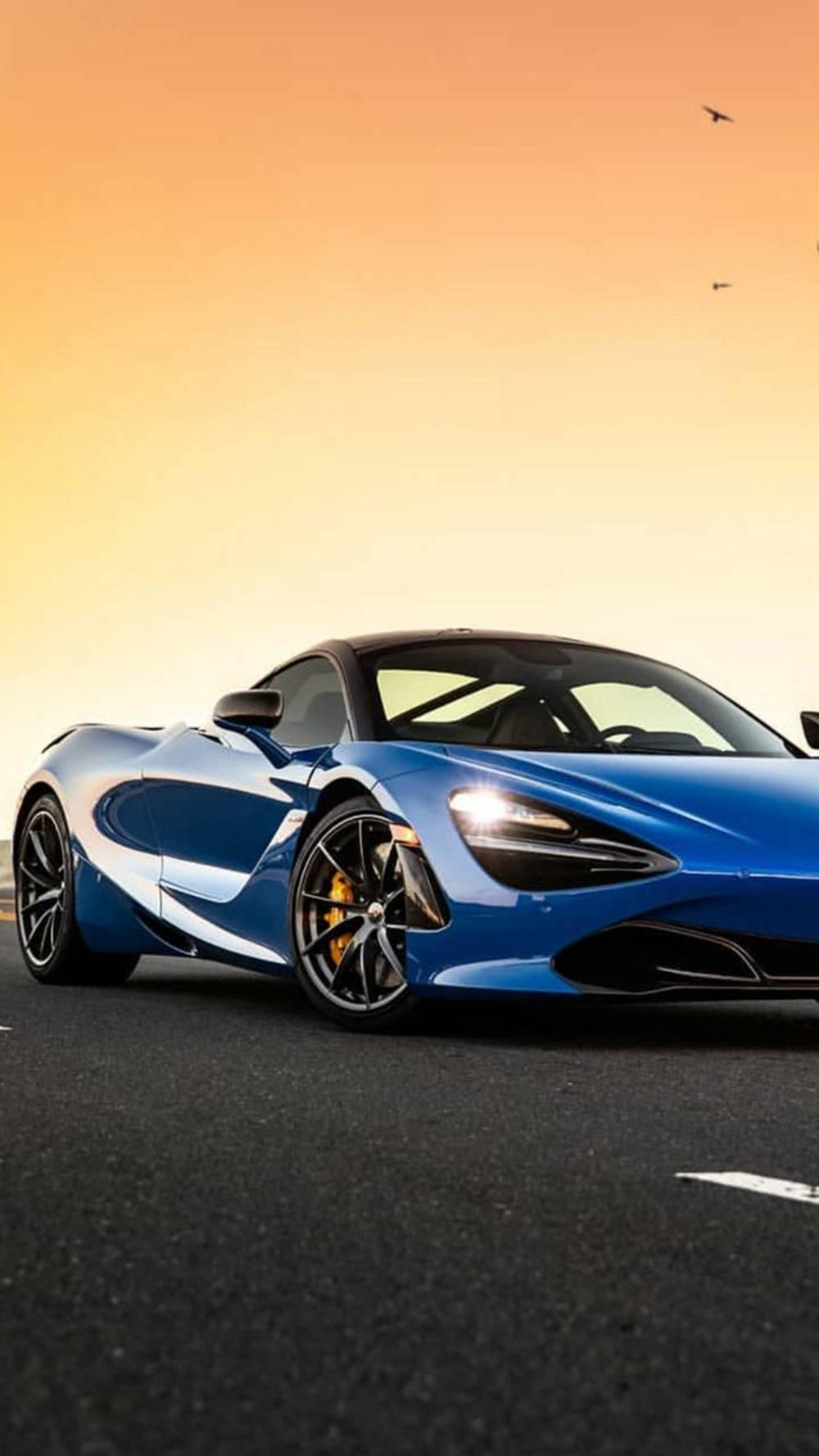 夕焼けの下に停まる青いマクラーレン720S 壁紙