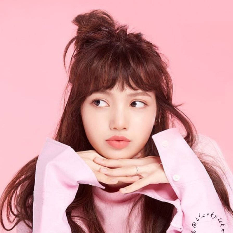 パステルピンクの壁の前でピンクのトップスを着たBLACKPINKリサの壁紙