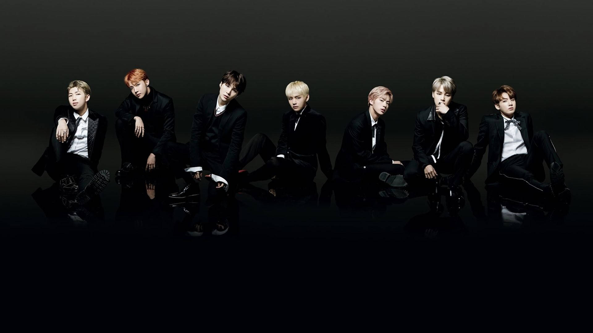 BTSメンバー黒のフロアで黒い服装のラップトップ 壁紙