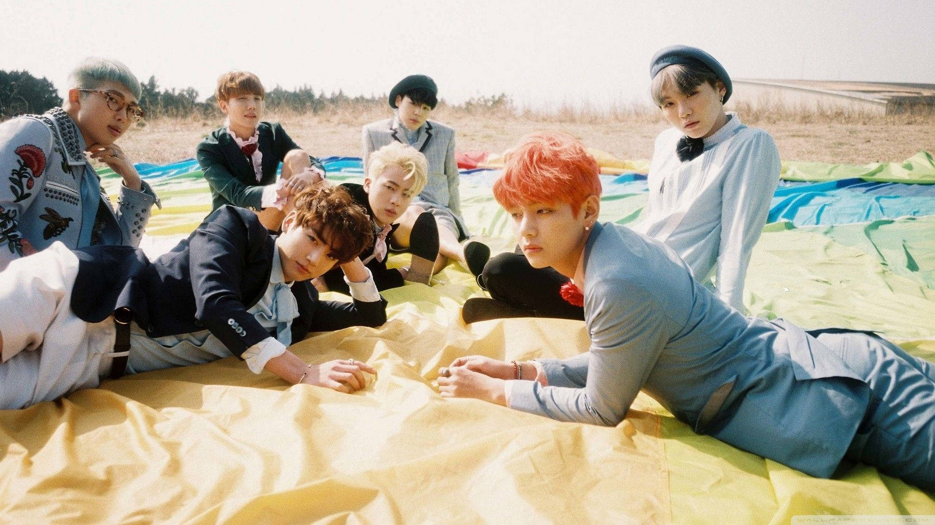 BTSメンバーがフィールドで寝そべるラップトップ 壁紙