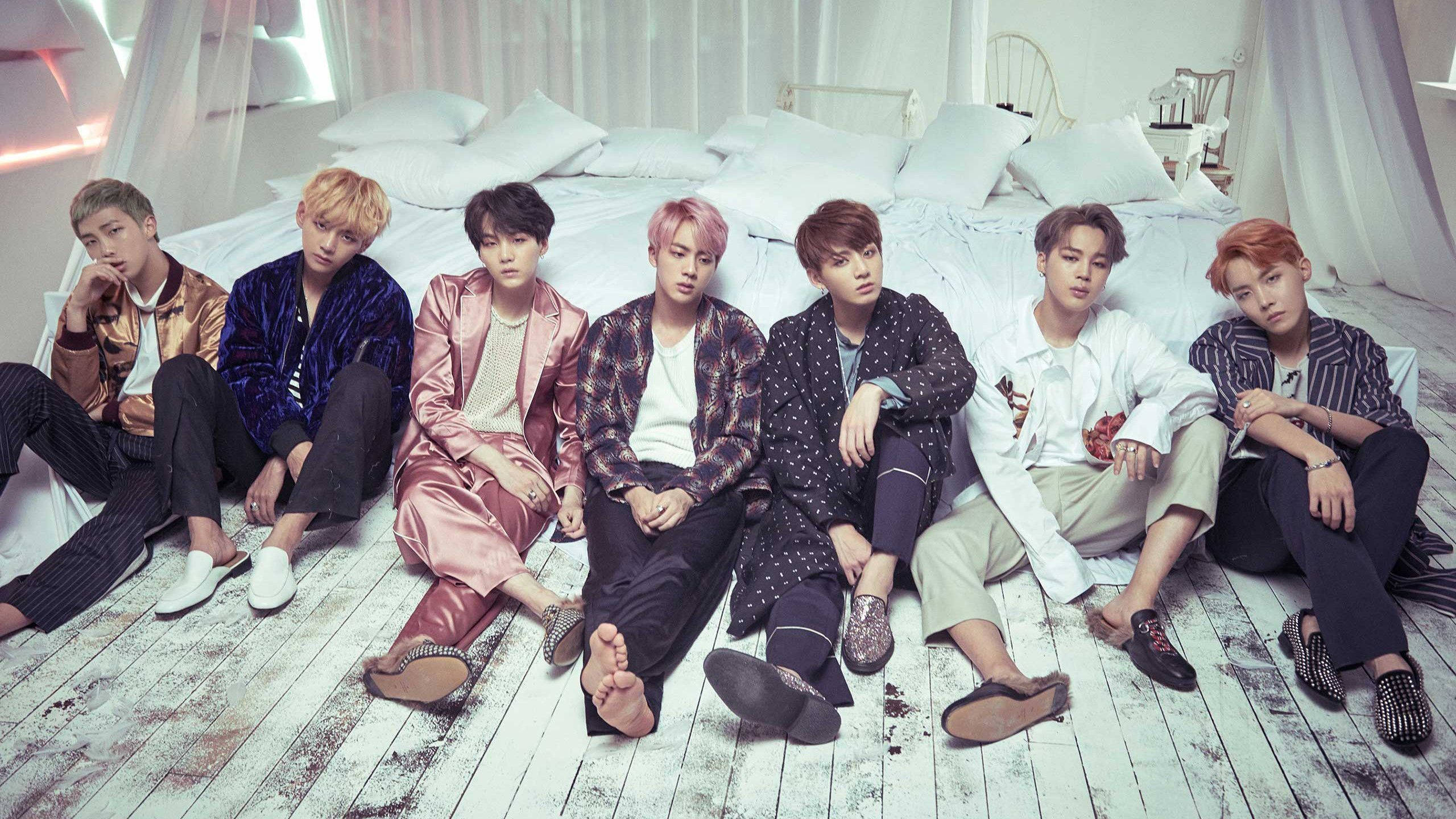 BTSメンバーがベッドのそばでラップトップ 壁紙