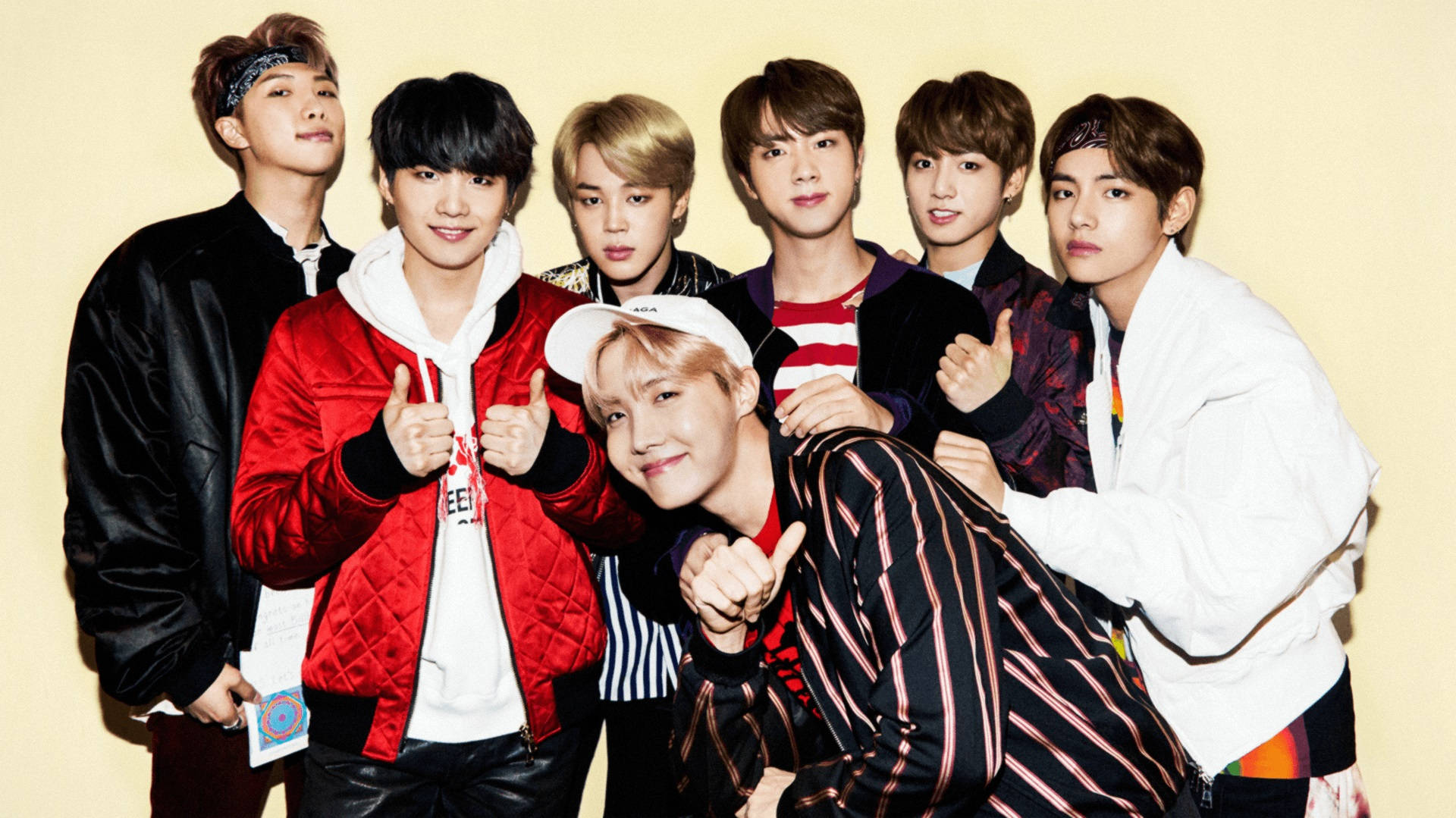 黄色い背景でポーズする可愛いBTS 壁紙