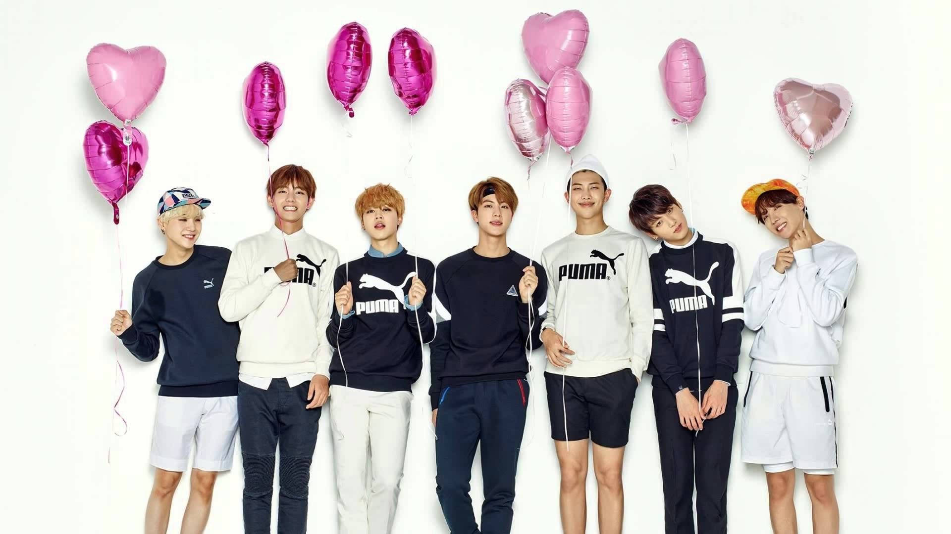 BTSが笑顔でハートの風船を持っている壁紙