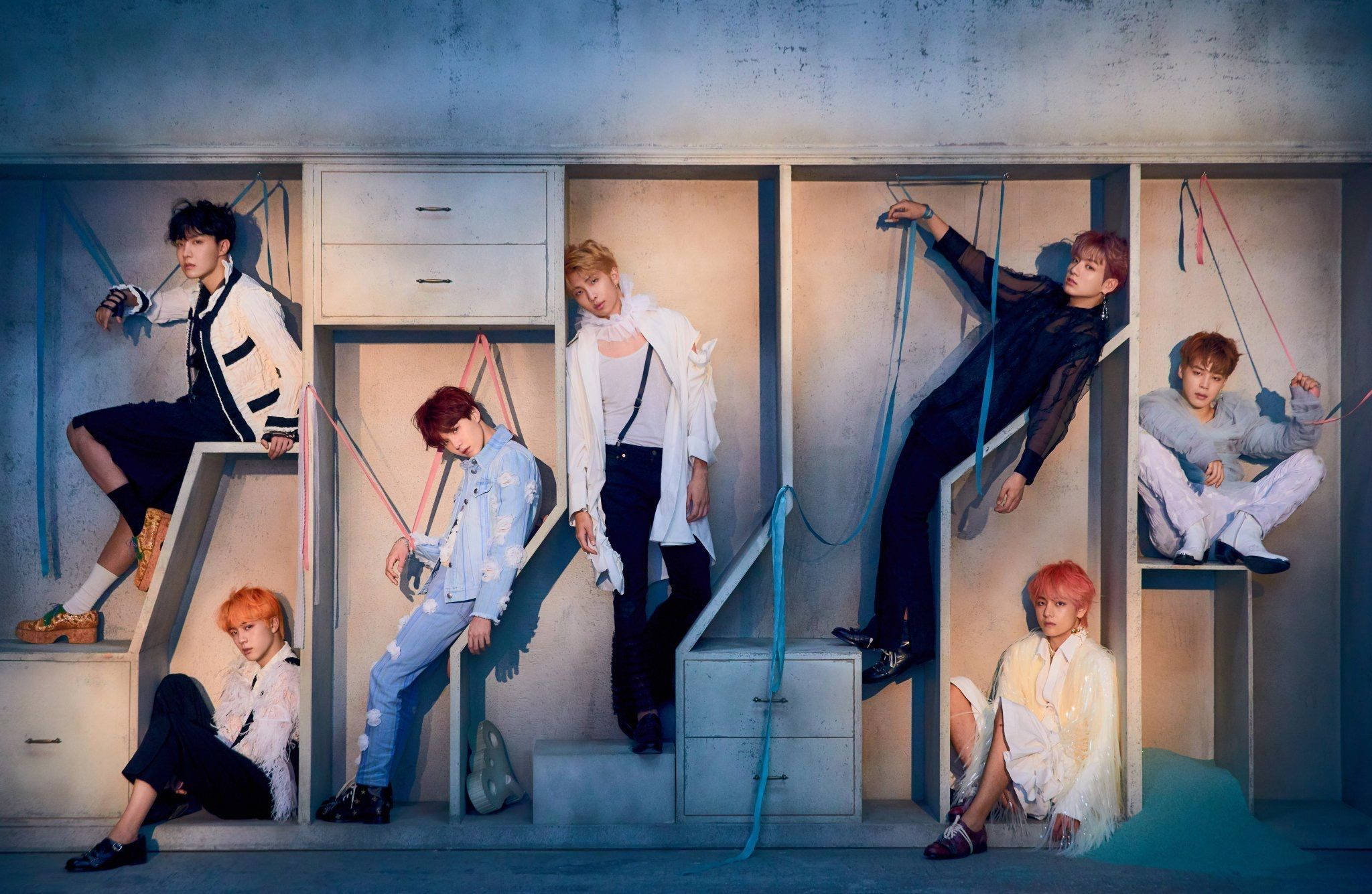 BTSメンバーがキャビネット棚でポーズするラップトップ 壁紙