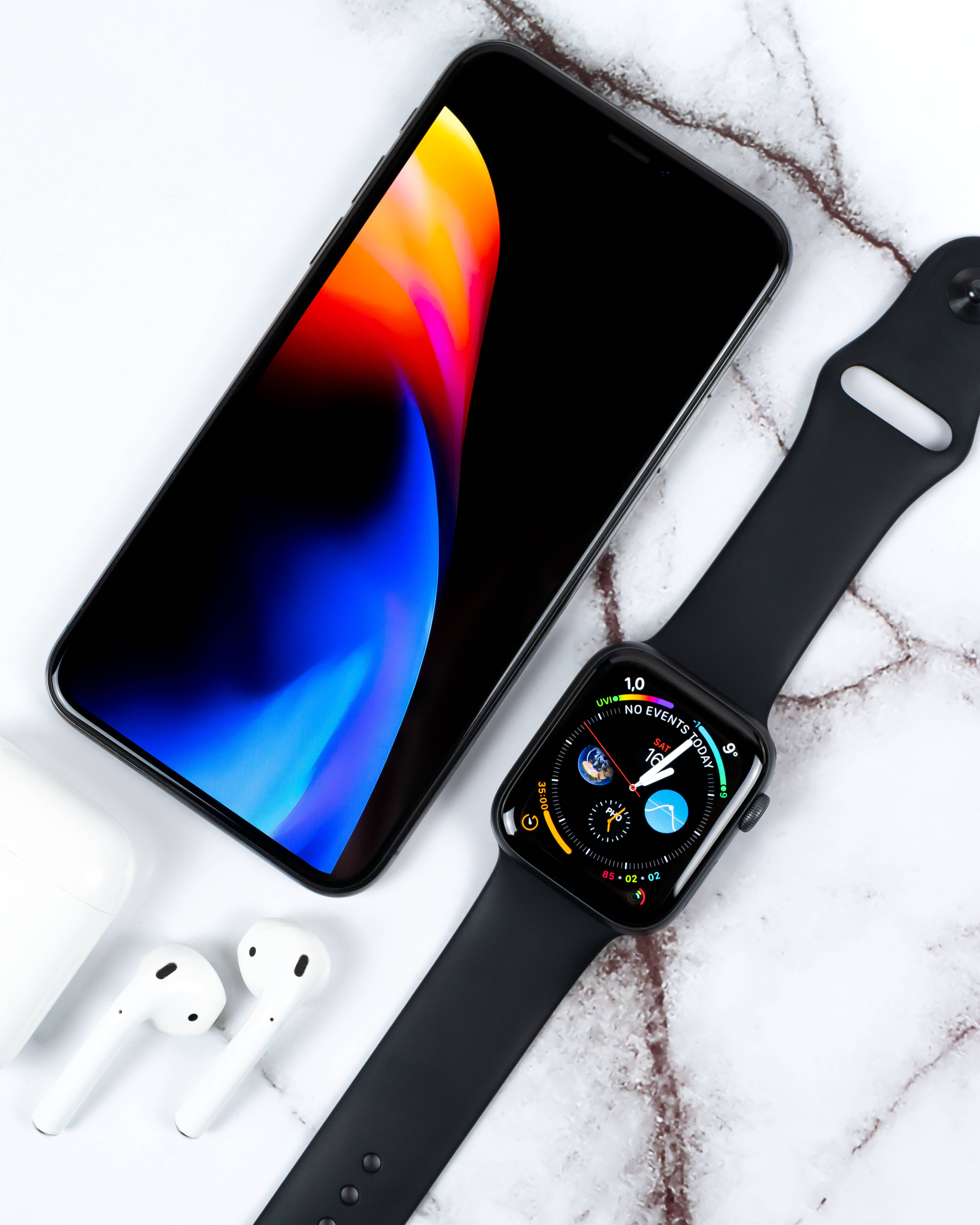 木のテーブルの上に置かれたエレガントなiPhone Xs 壁紙
