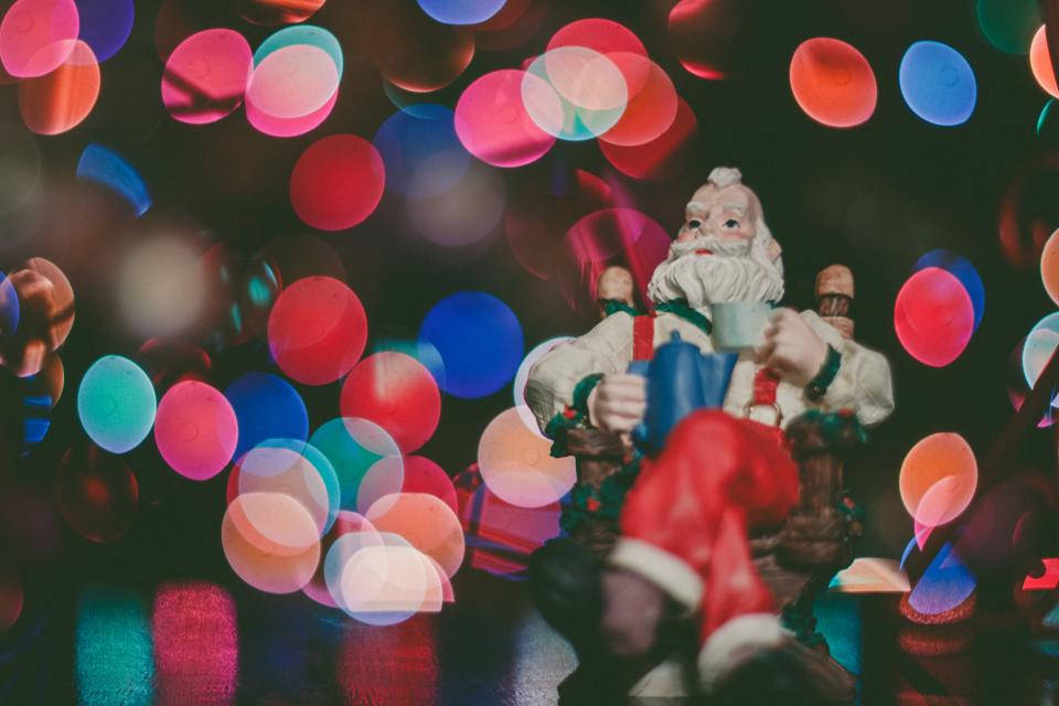 サンタの置物とカラフルなクリスマスライト 壁紙