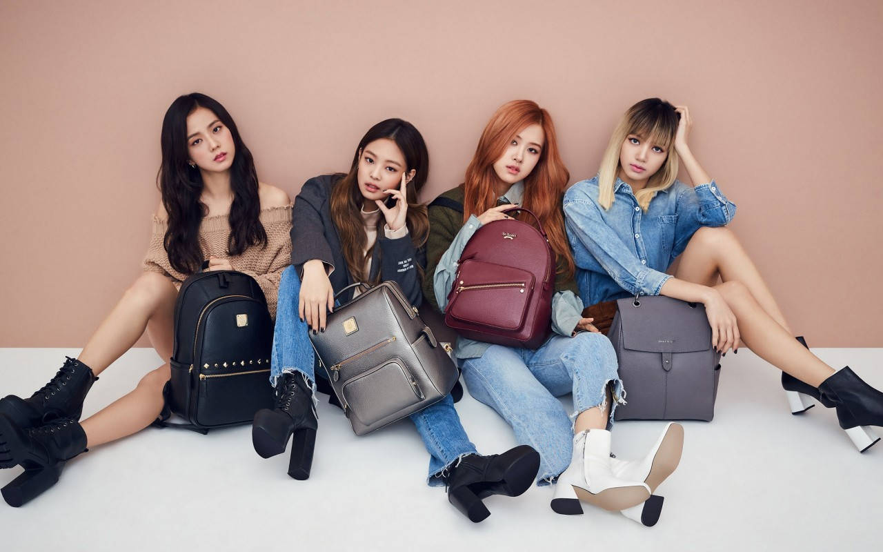 ベージュの壁の前でバックパックを背負ったBLACKPINKメンバーの壁紙