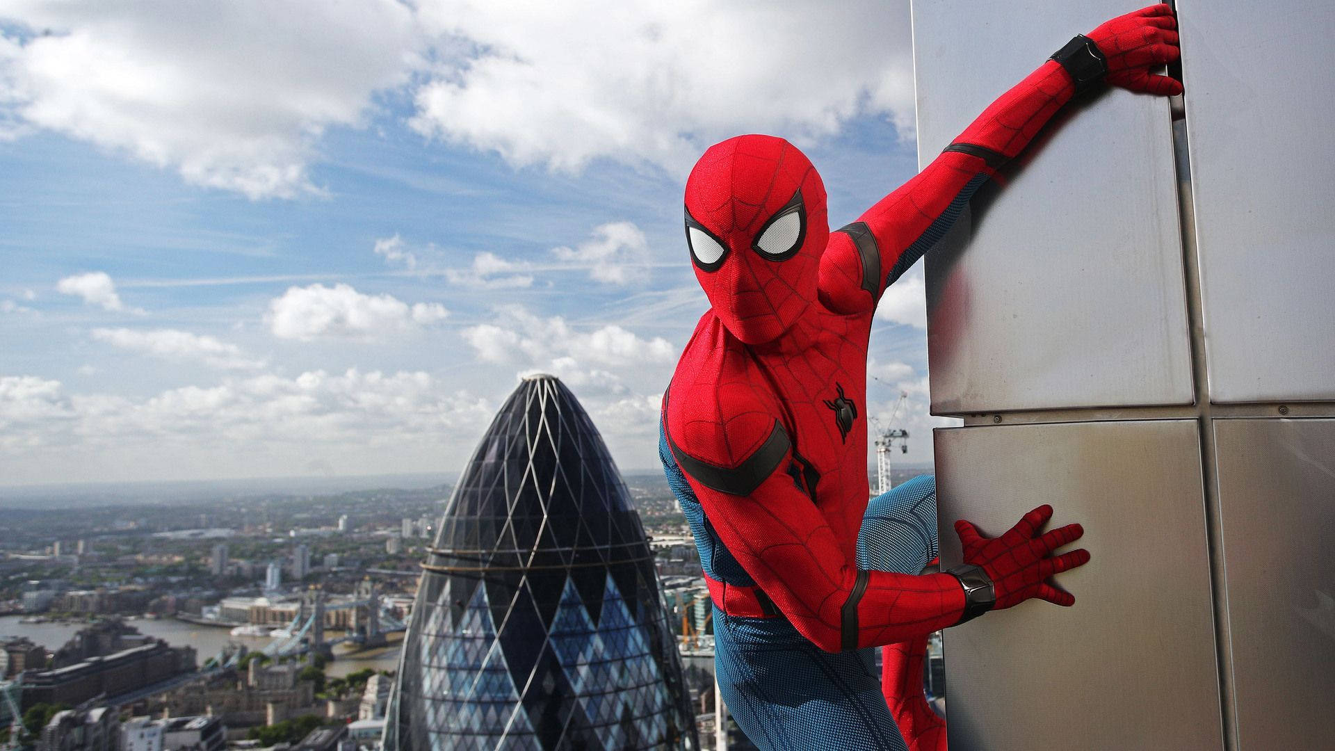 スパイダーマンが建物の端にぶら下がり、立っている