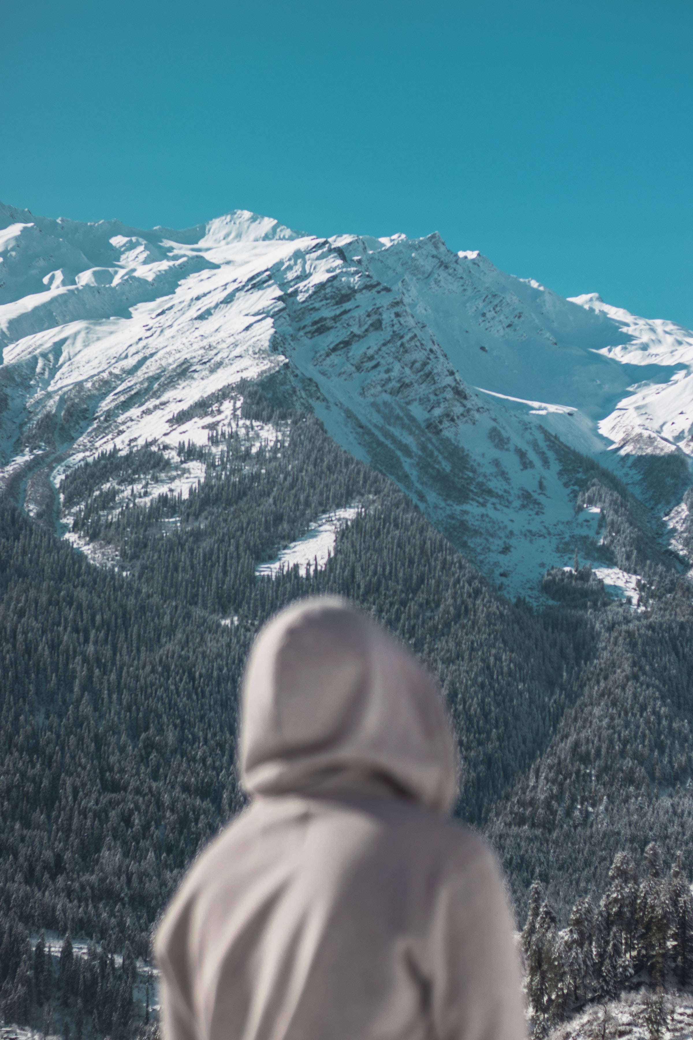 フードをかぶった人物の横顔と雪山 壁紙