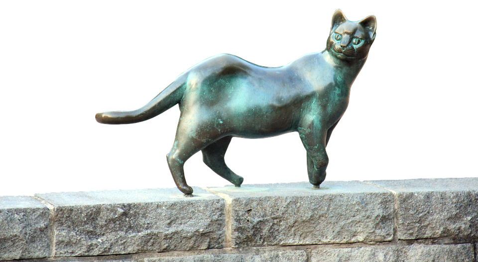 ブロンズの猫の彫刻と石の棚 壁紙