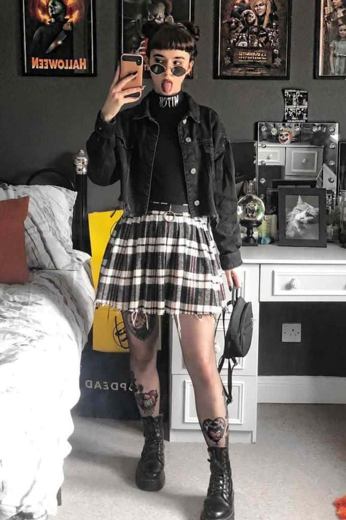 プリーツスカートと黒いジャケットを着た少女が自撮りをする 壁紙