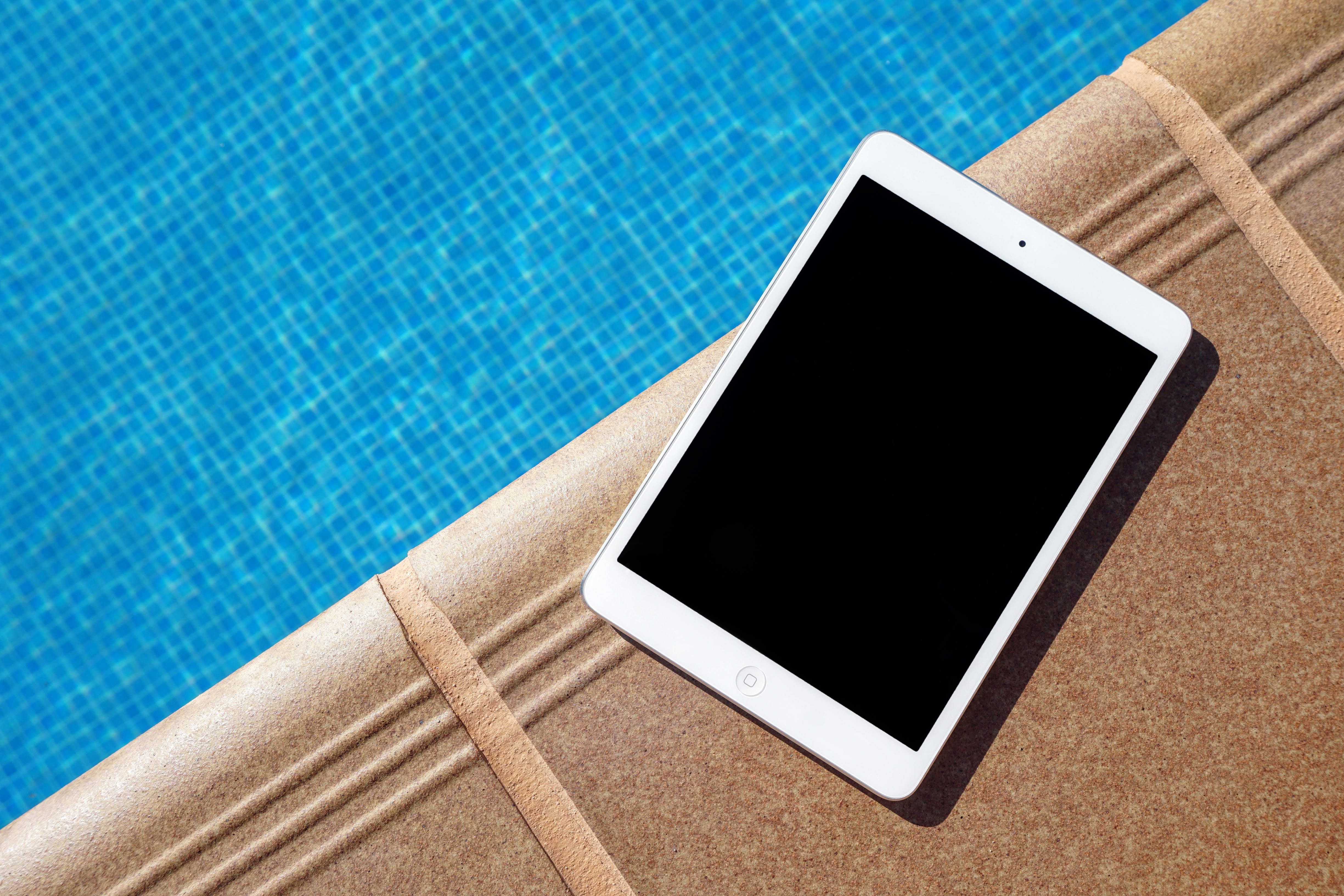 ミニマルなグレーのデスクに置かれたスタイリッシュなシルバーのiPad 壁紙