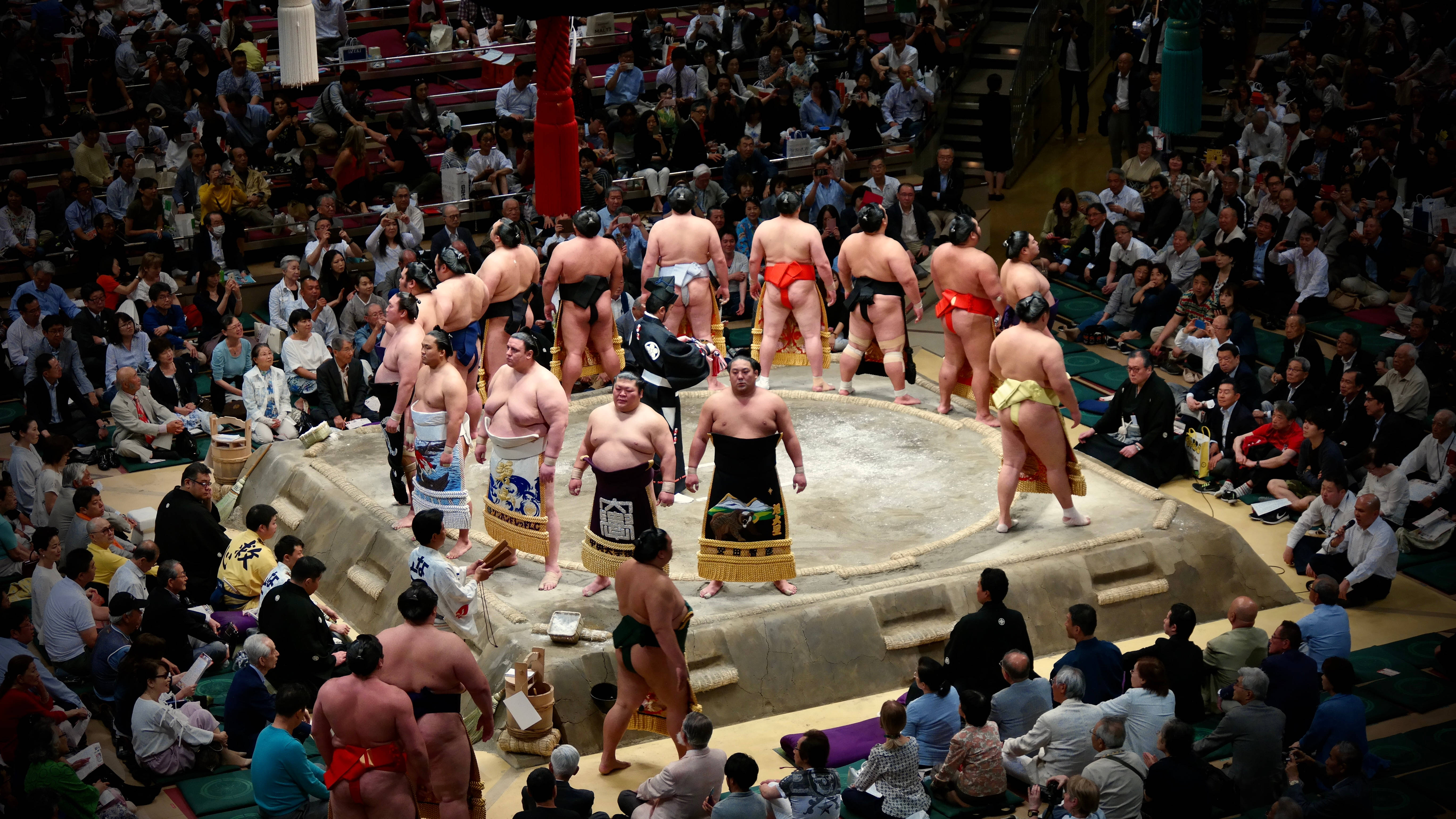 伝統的な日本の土俵で激しくぶつかり合う二人の力士 壁紙