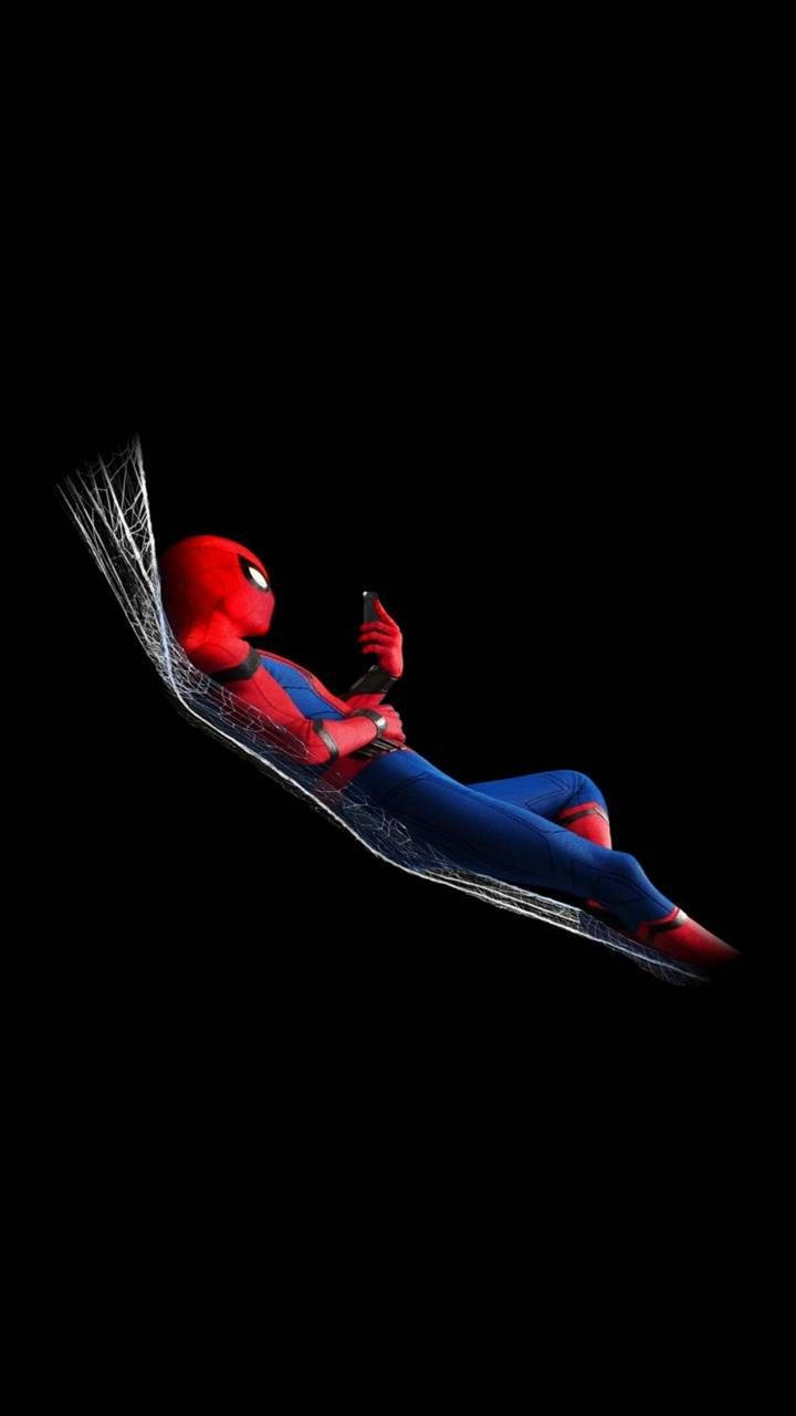 スパイダーマンが黒い背景でクモの糸の上で休んでいる。