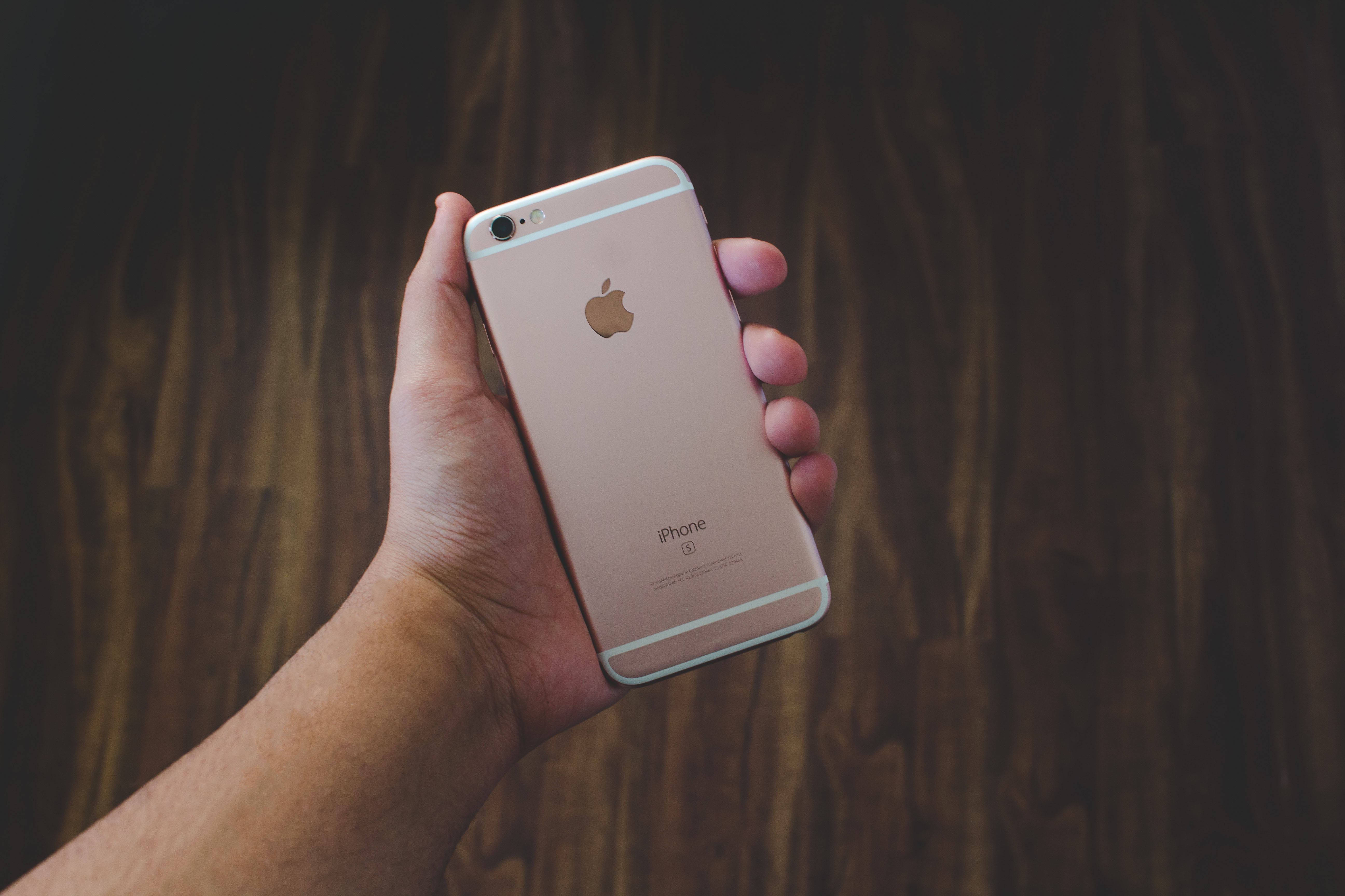 手に持ったローズゴールドのiPhone 6 壁紙
