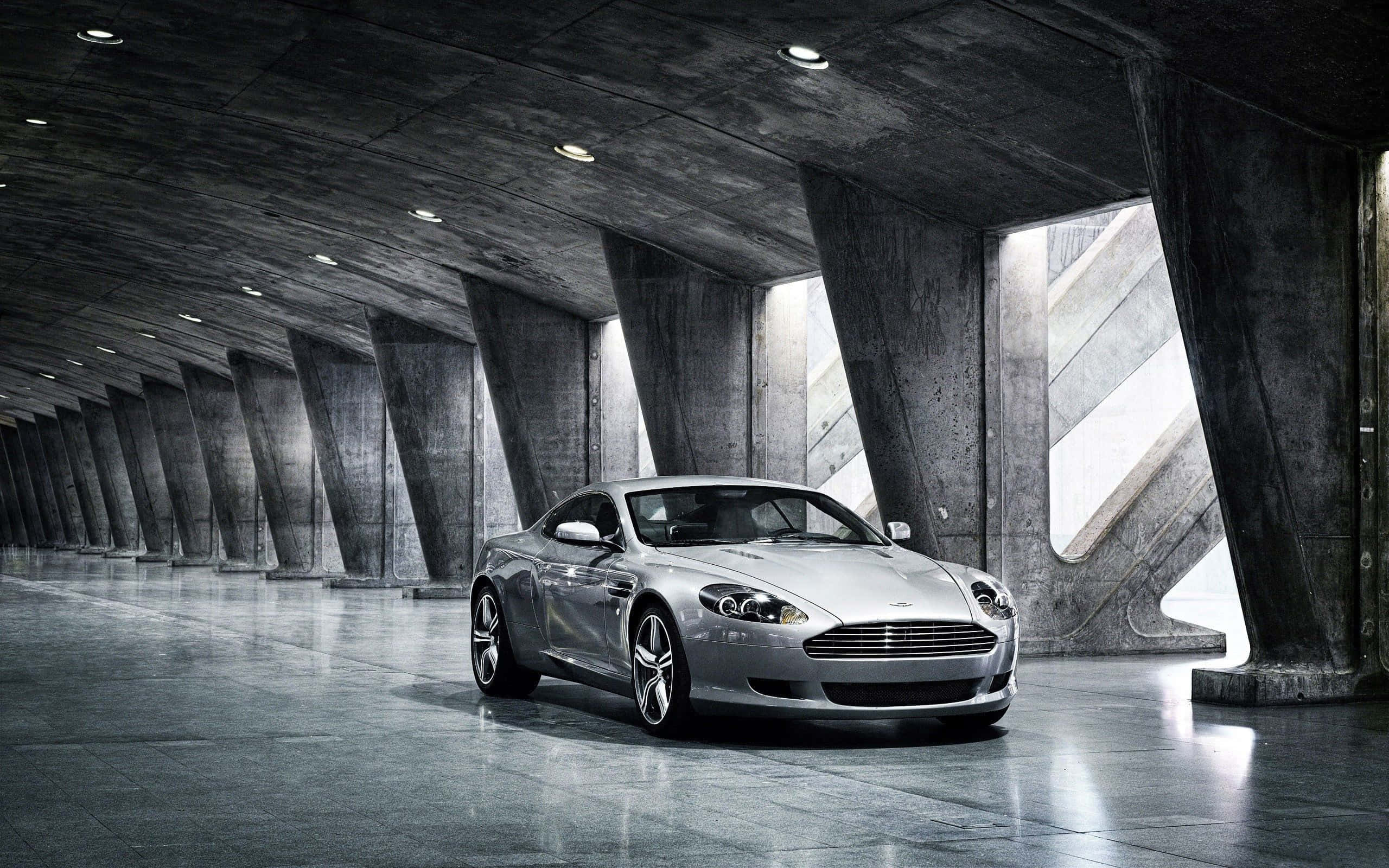 景観の美しい都市景をクルージングするアストンマーティン DB9 壁紙