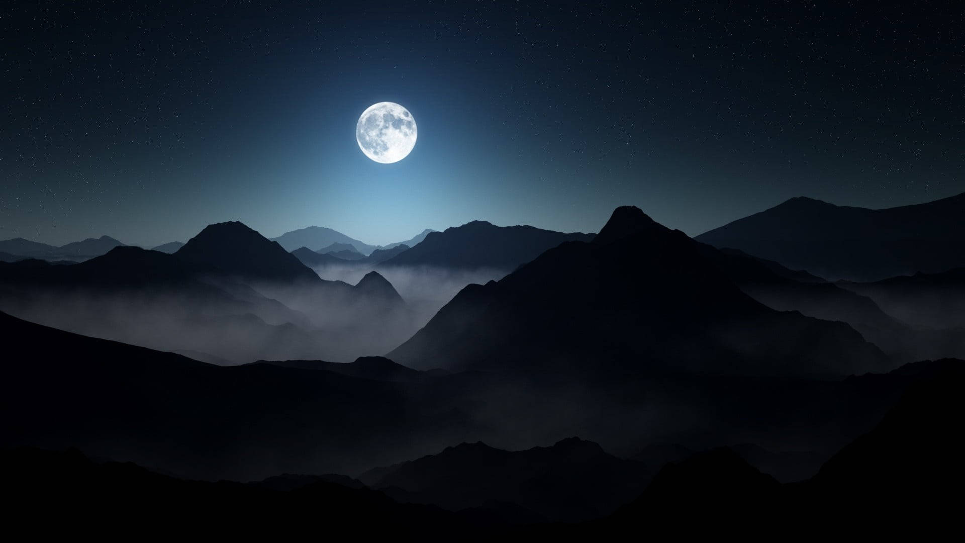 暗い夜の山々に浮かぶ満月とノートパソコン