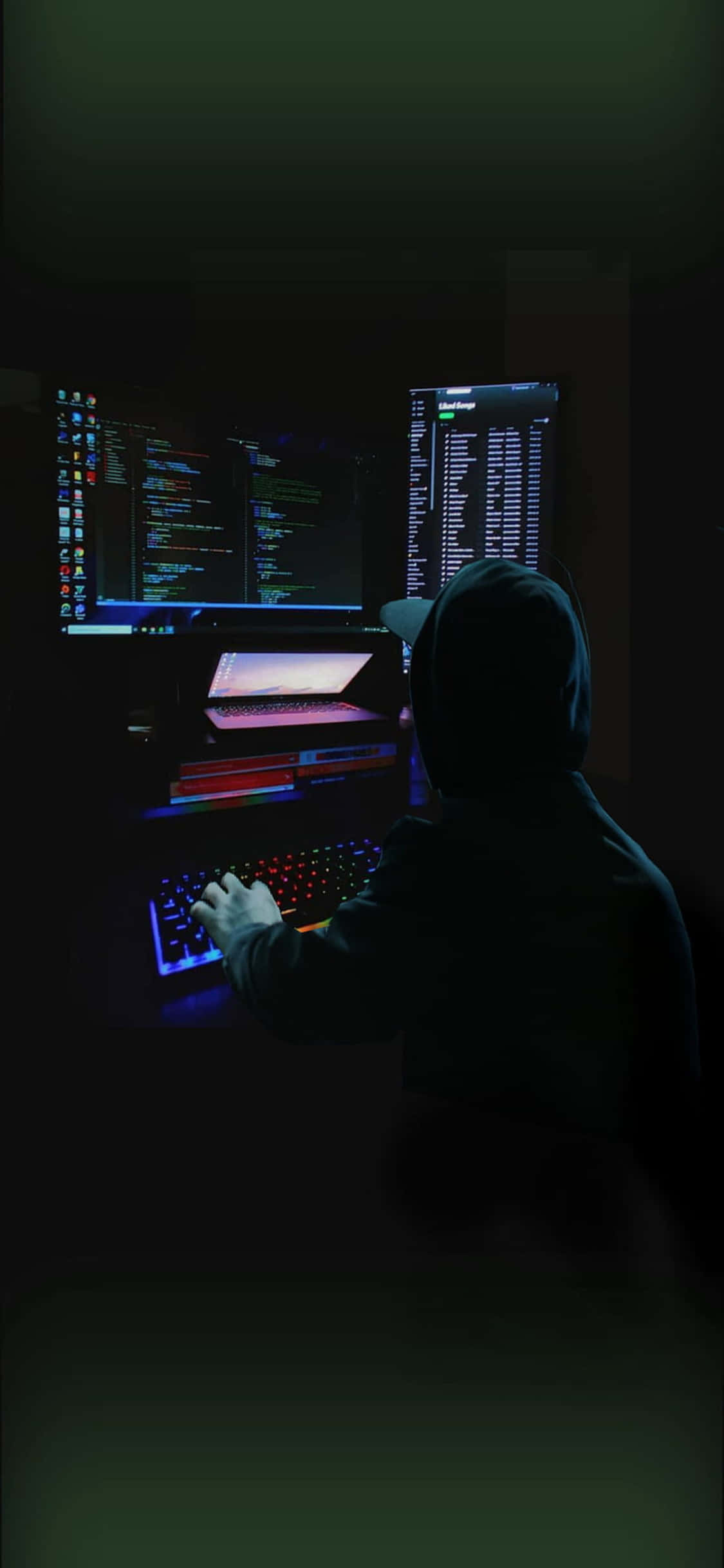 暗闇でコンピュータに座る男性 壁紙
