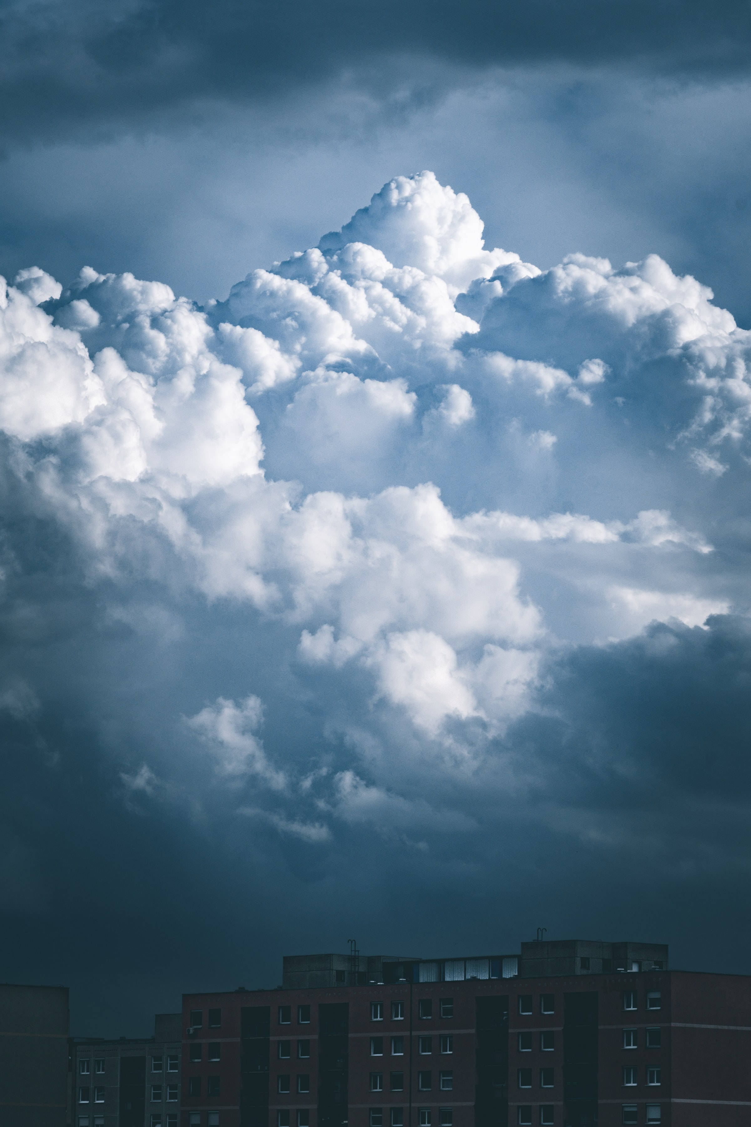 曇天のビル群と暗い雲 壁紙