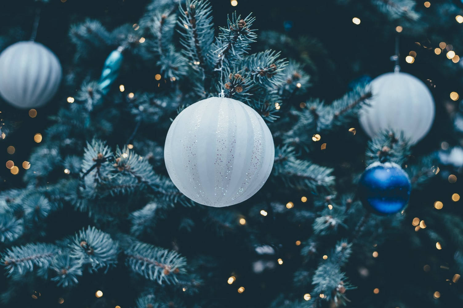 白いクリスマスボールのアップ（お祭りの木に飾られた） 壁紙