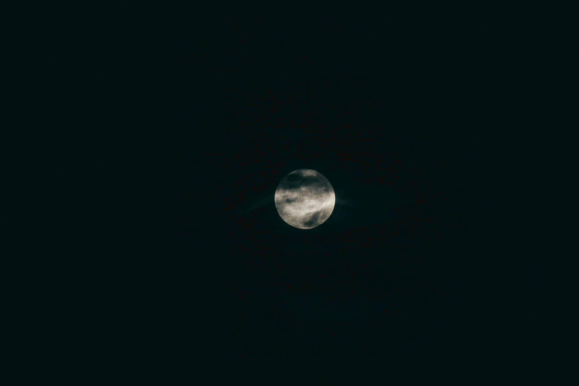 暗い真夜中の空に浮かぶ満月。漆黒の宇宙空間に月光が輝く。