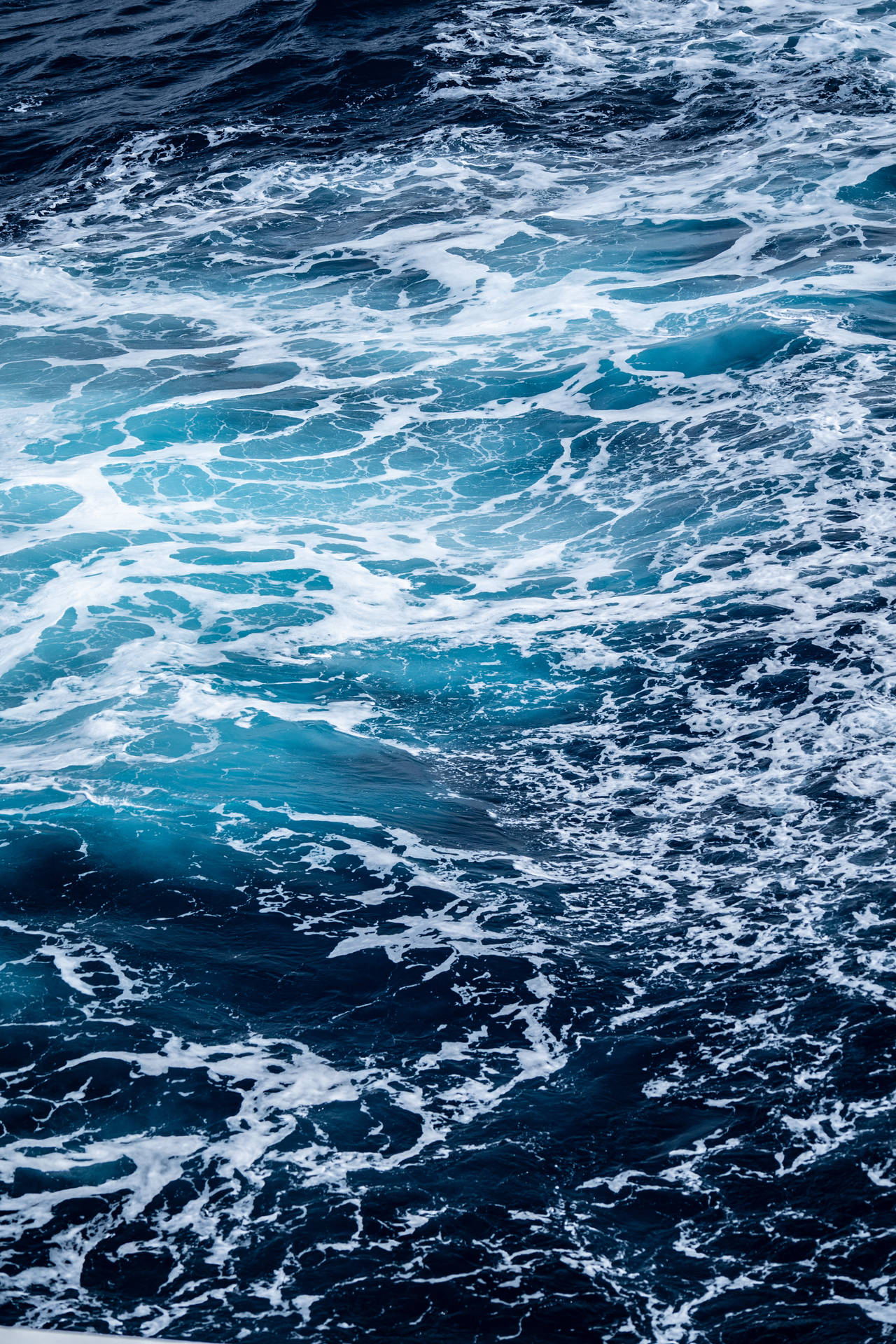 明るい日に大きな波と水しぶきが立つ海