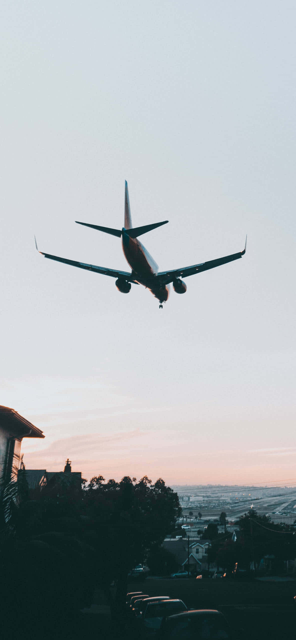 街の上空を飛ぶ飛行機 壁紙