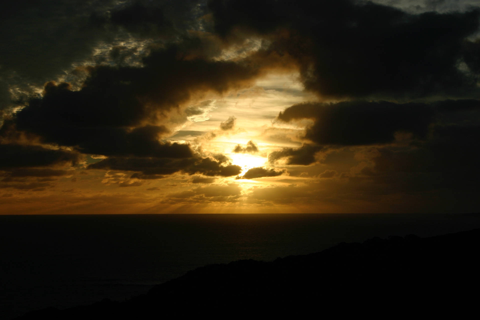 暗い雲の背後にある空の夕日。