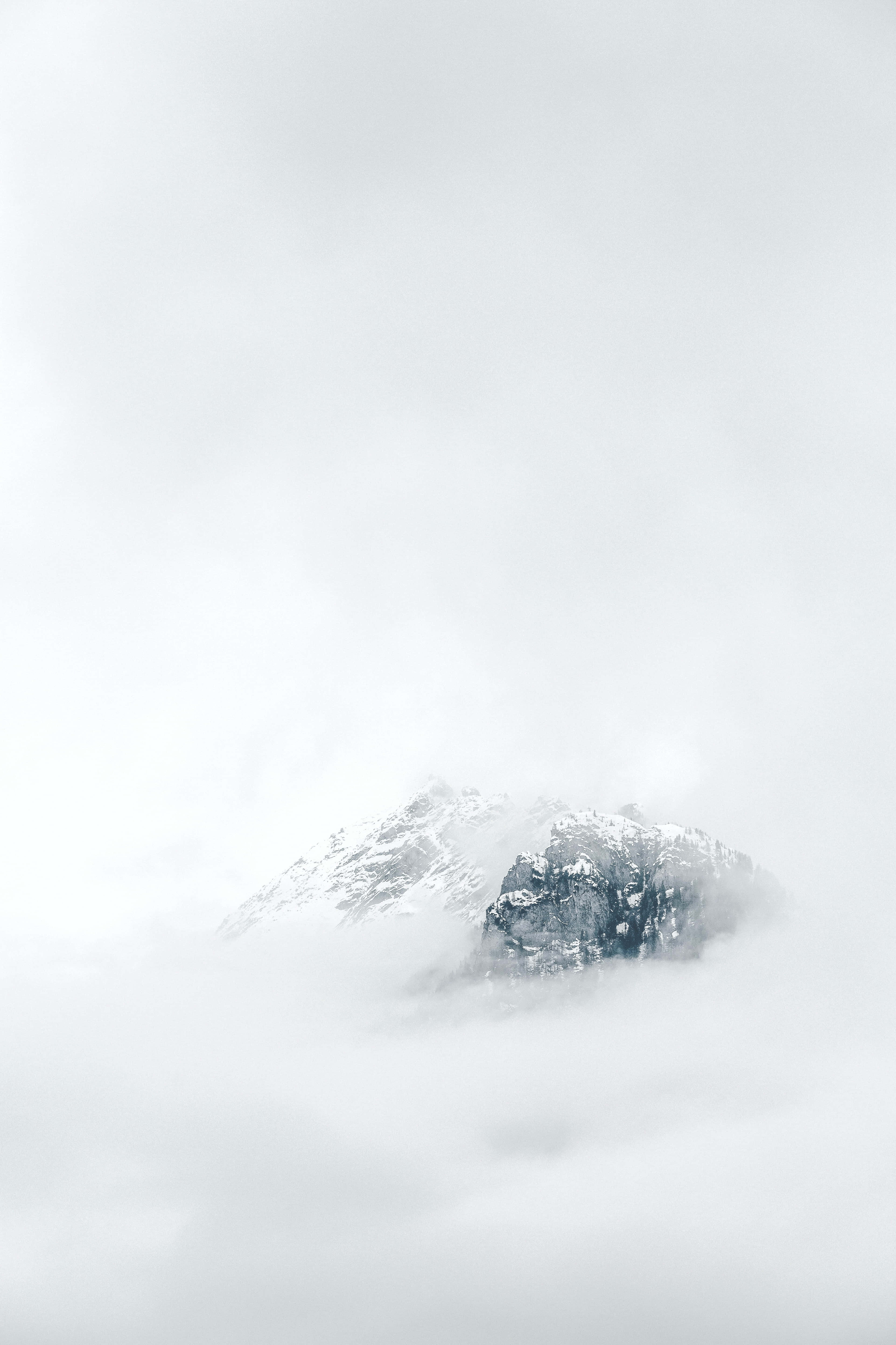 雲に覆われ、頂上に雪を戴いた山 壁紙