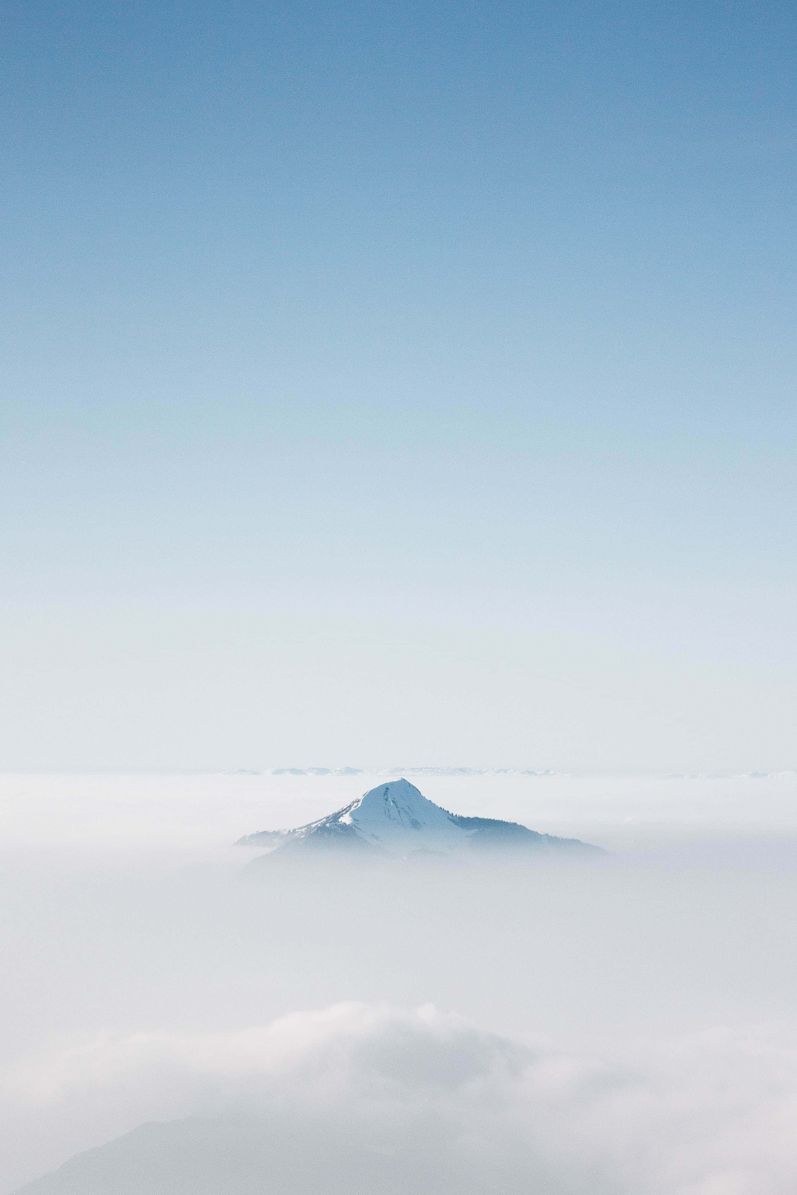 雲を突き抜ける山のブルー・エステティック背景 壁紙