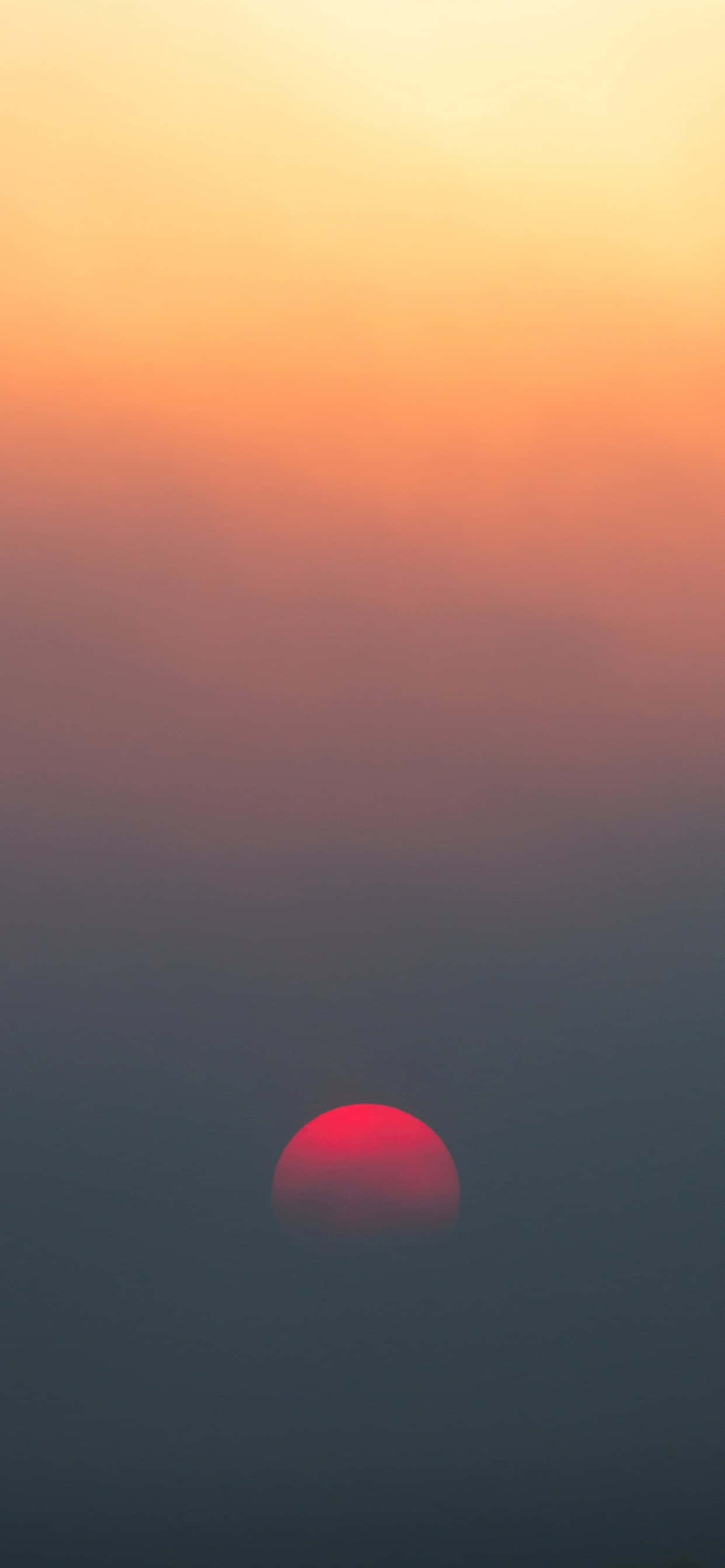 霧で満ちた空に昇る赤い太陽 壁紙