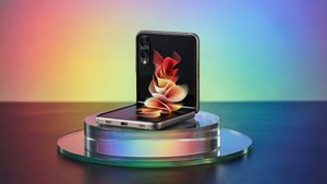 ガラススタンドに置かれたZ Flip 5を、鮮やかなグラデーション背景でクリーンに撮影したスタジオショット。