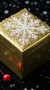 黒い表面に雪の結晶とベリーが飾られた、輝く金色のプレゼント — iPhone 7 壁紙