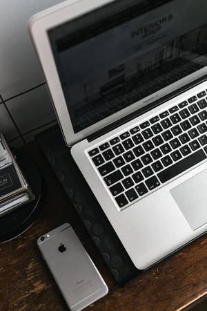 シルバーMacBookとiPhoneデスク — Xiaomi Pad 7 Ultra 壁紙