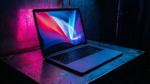 暗い部屋でネオンの反射を放つ、サイバーパンクに着想を得たMacBook。