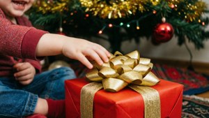 クリスマスツリーの下にある赤いプレゼントに手を伸ばす子どもの手。 — クリスマスプレゼント 壁紙