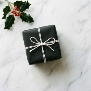 大理石の表面にヒイラギを添えたシンプルな白黒のプレゼント。 — クリスマスプレゼント 壁紙