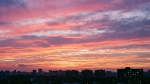 カラフルな夜明けの空が、街のスカイラインのシルエットを背景に広がる。 — 空の眺め 壁紙