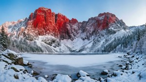 雪に覆われた赤い山と凍った湖のある冬の風景