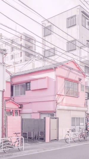 白い建物の隣にあるピンクの美しい家 — パステルピンクの美学 壁紙